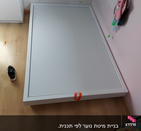 לוח עץ לבן מונח על רצפת עץ